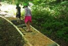 Zwei Kinder auf einem Barfußpfad im Wald