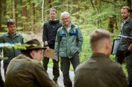 Forstschüler stehen mit ihrem Ausbilder im Kreis im Wald